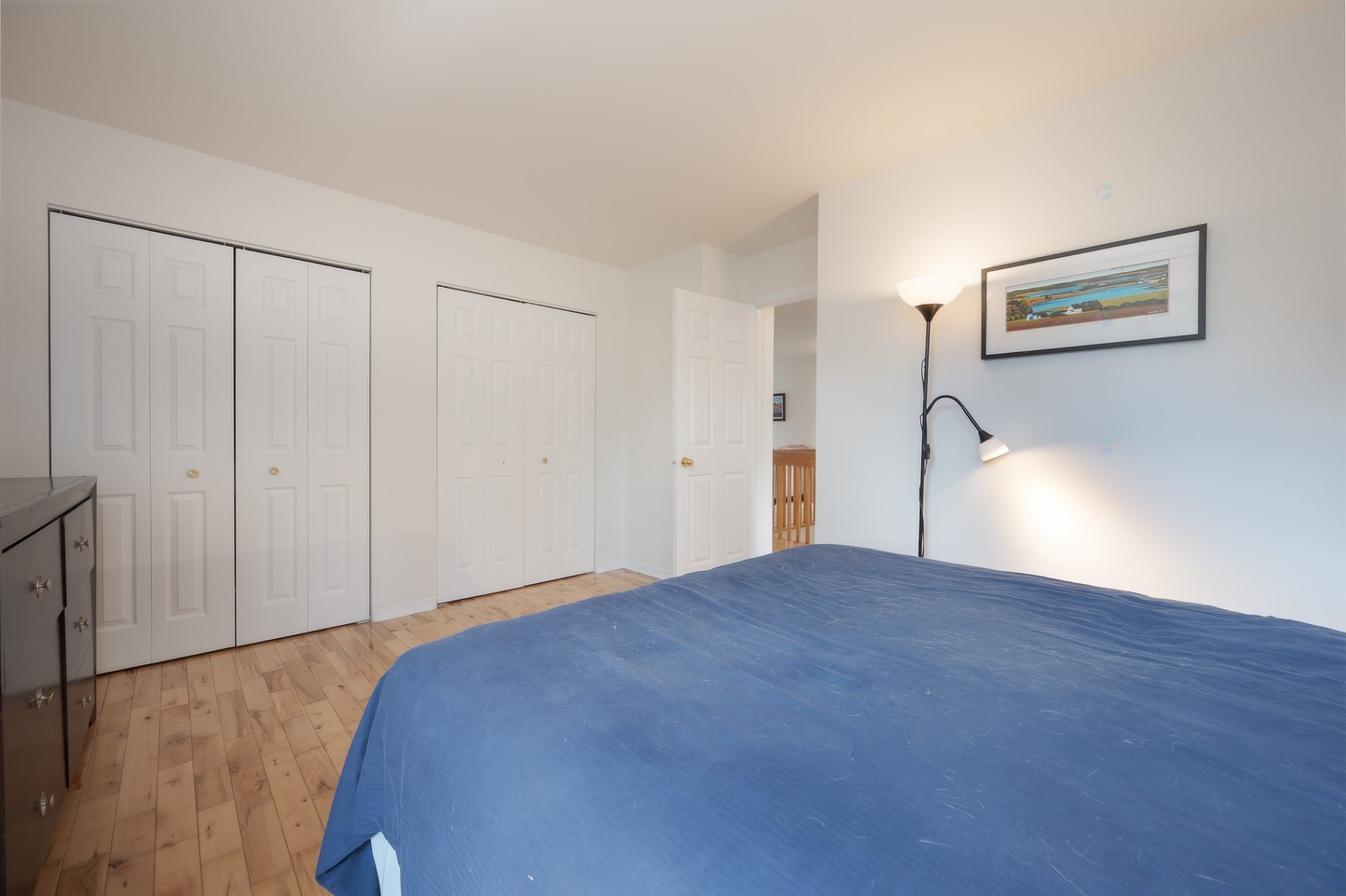 Primary bedroom with wood floors, double closets, large window
