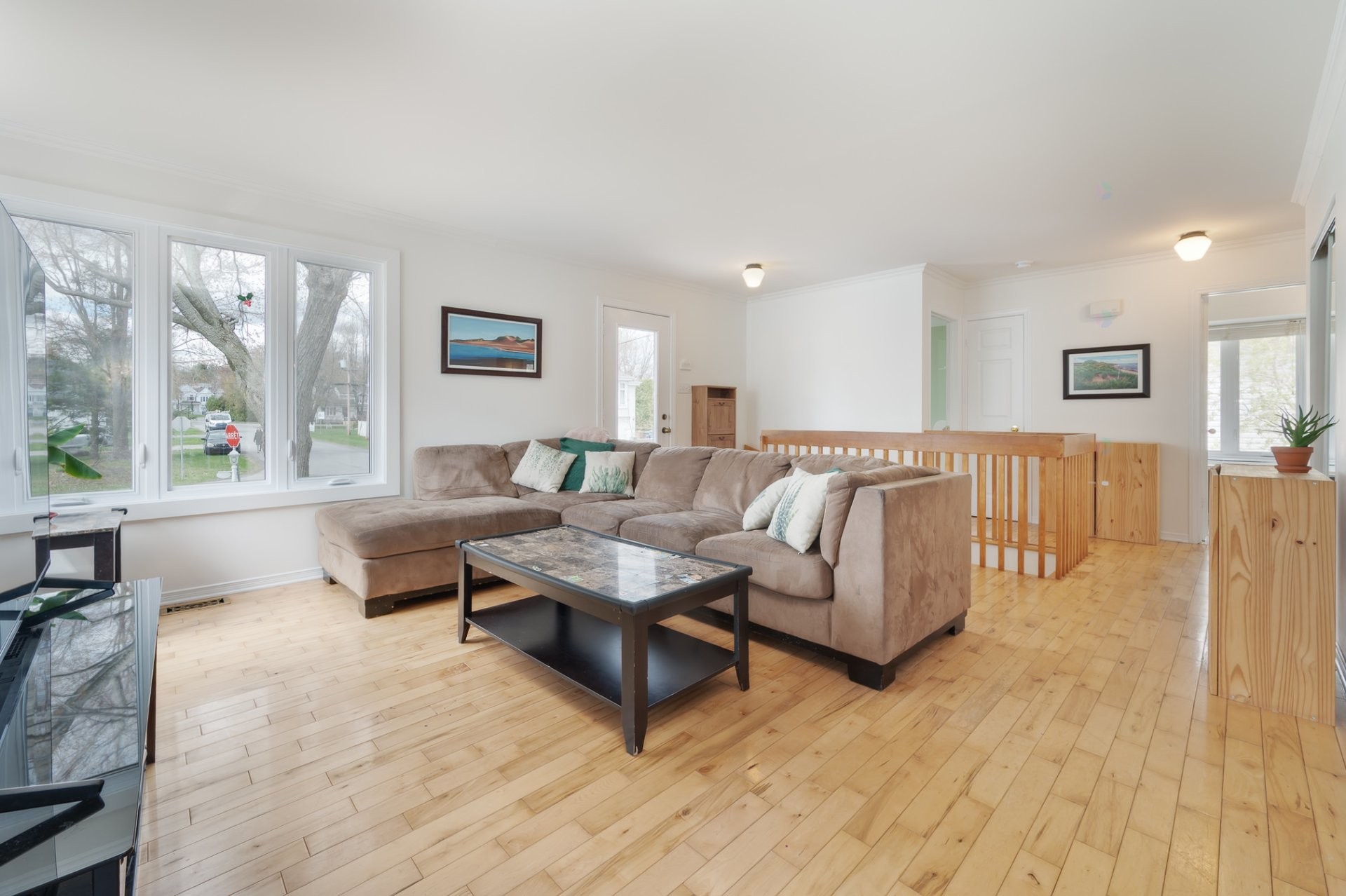 Living room with wide front windows, wood floors, sectional sofa